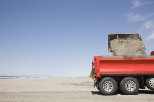 54657,Truck shoveling sand on beach