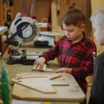 Boys work in a joinery workshop making craft of wood