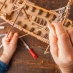 Man collects the vehicle model on the wooden table