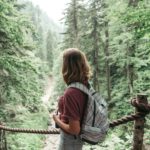 Rear view of a woman with a backpack in the mountains in a nature reserve.