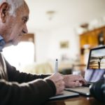 Senior photographer working with laptop